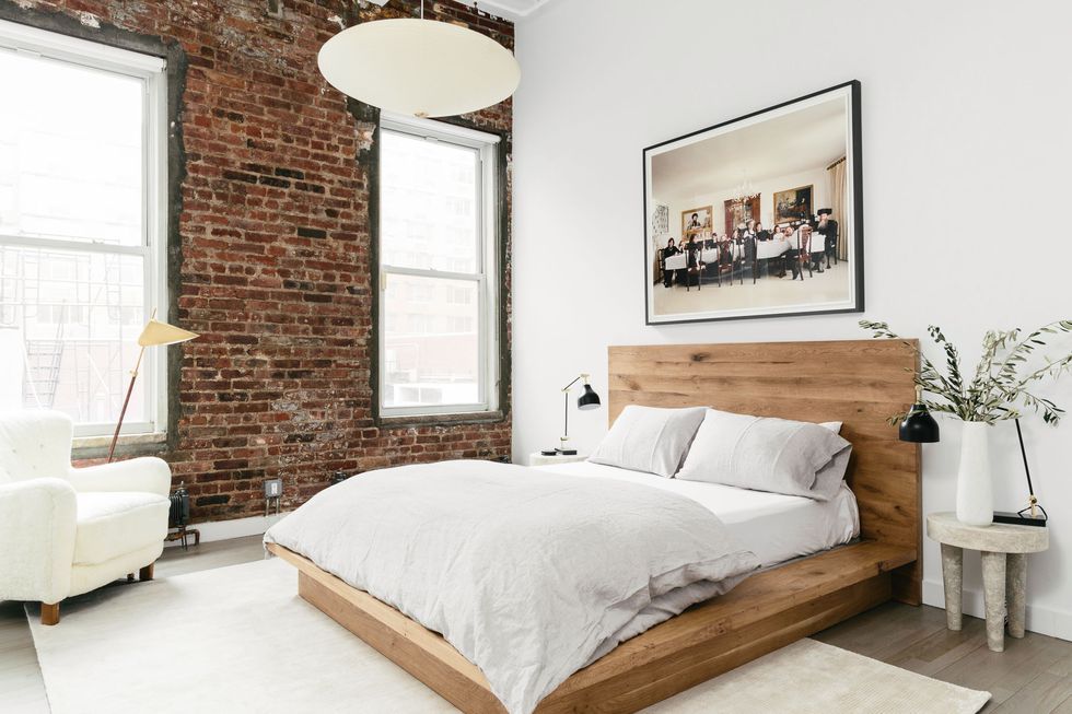 Chiếc giường từ gỗ tự nhiên kết hợp với bức tường gạch tạo nên vẻ mộc mạc, thân thiện cho căn phòng